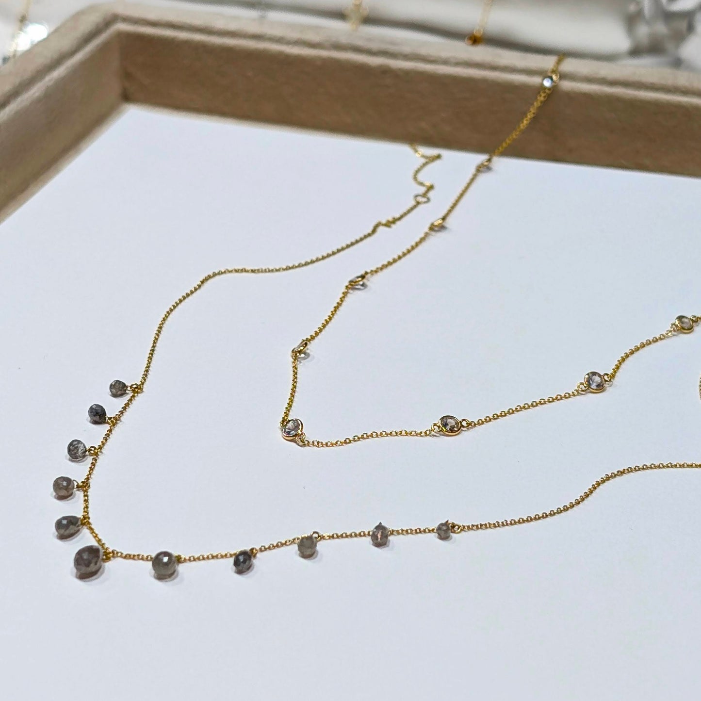 Gold necklace with small beads on a white surface