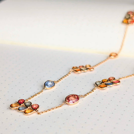 Necklace with multicolored gemstones on a light gray background