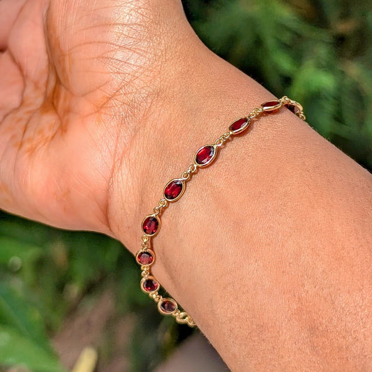 This bracelet captures the strength of a chain and the glow of natural garnets, crafted in solid 18K gold.