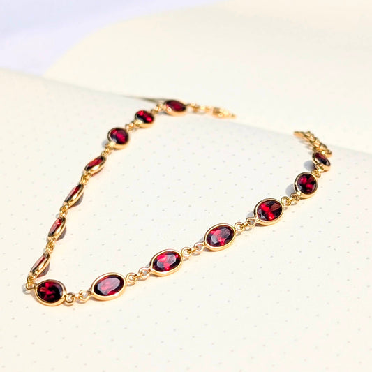 This bracelet captures the strength of a chain and the glow of natural garnets, crafted in solid 18K gold.