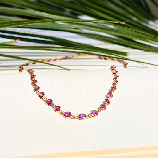 Crafted in solid 18K gold and embellished with vivid rhodolite garnets all around on this necklace