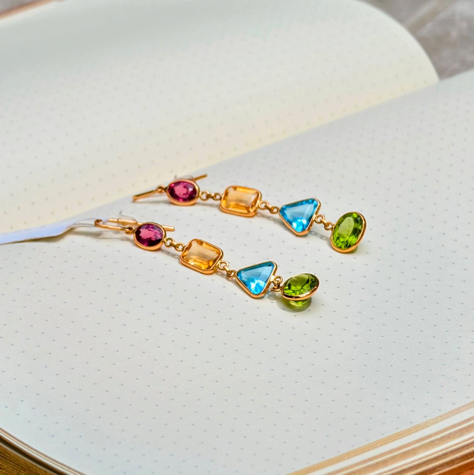 Crafted in solid 18K gold, these striking dangle earrings bring together a vibrant mix of natural gemstones, each cut in a distinct shape to celebrate individuality.