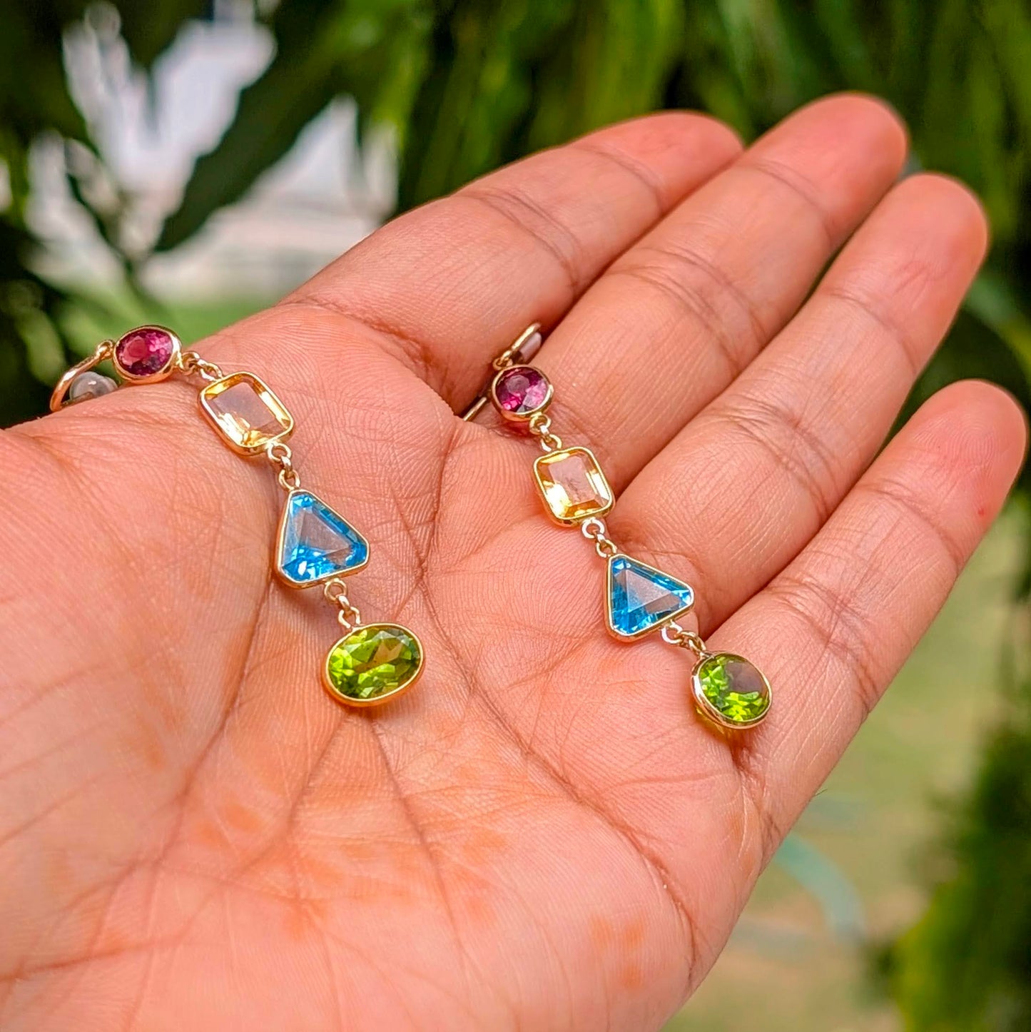 Crafted in solid 18K gold, these striking dangle earrings bring together a vibrant mix of natural gemstones, each cut in a distinct shape to celebrate individuality.