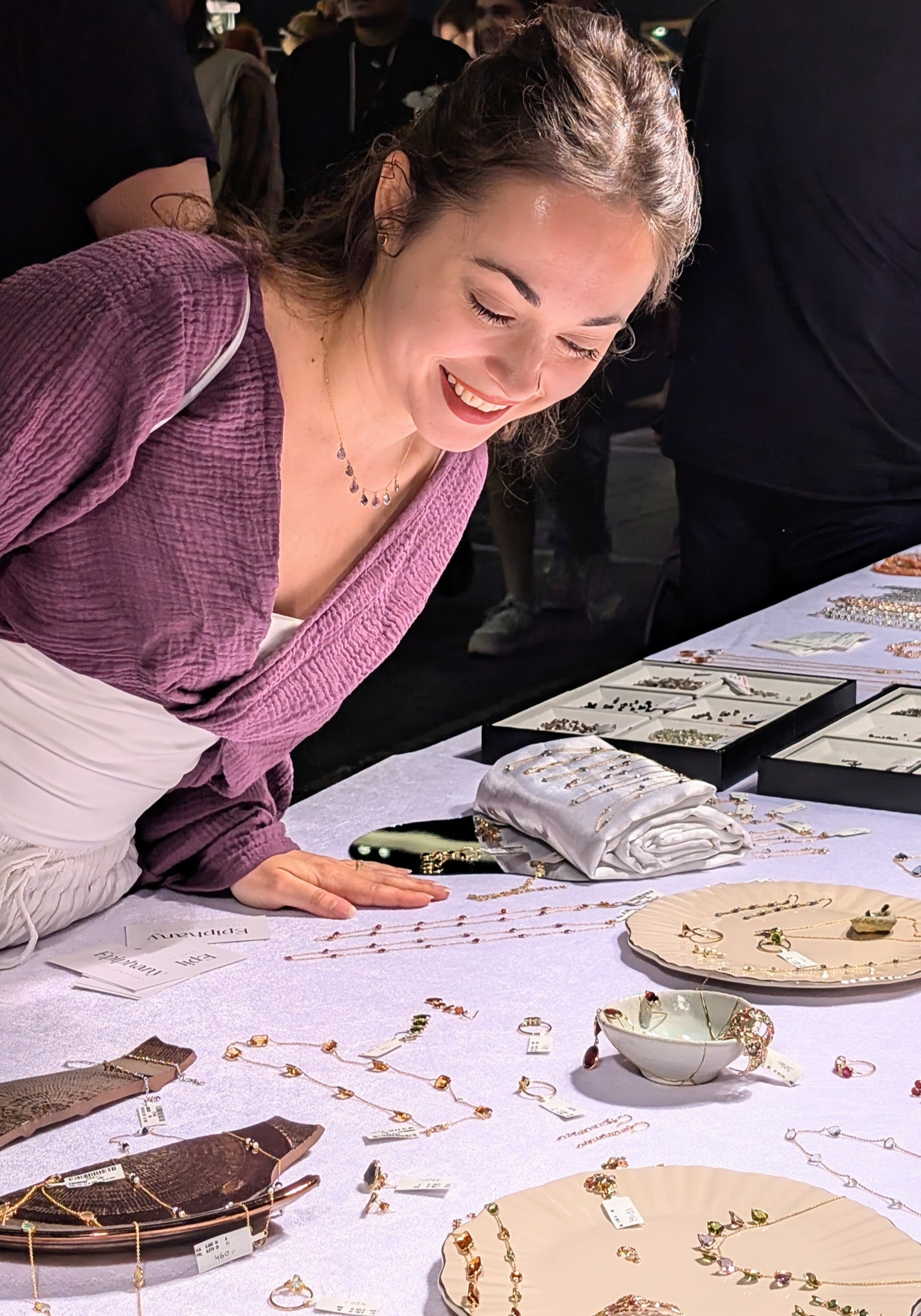 Woman examining artifacts on a table with a dark background