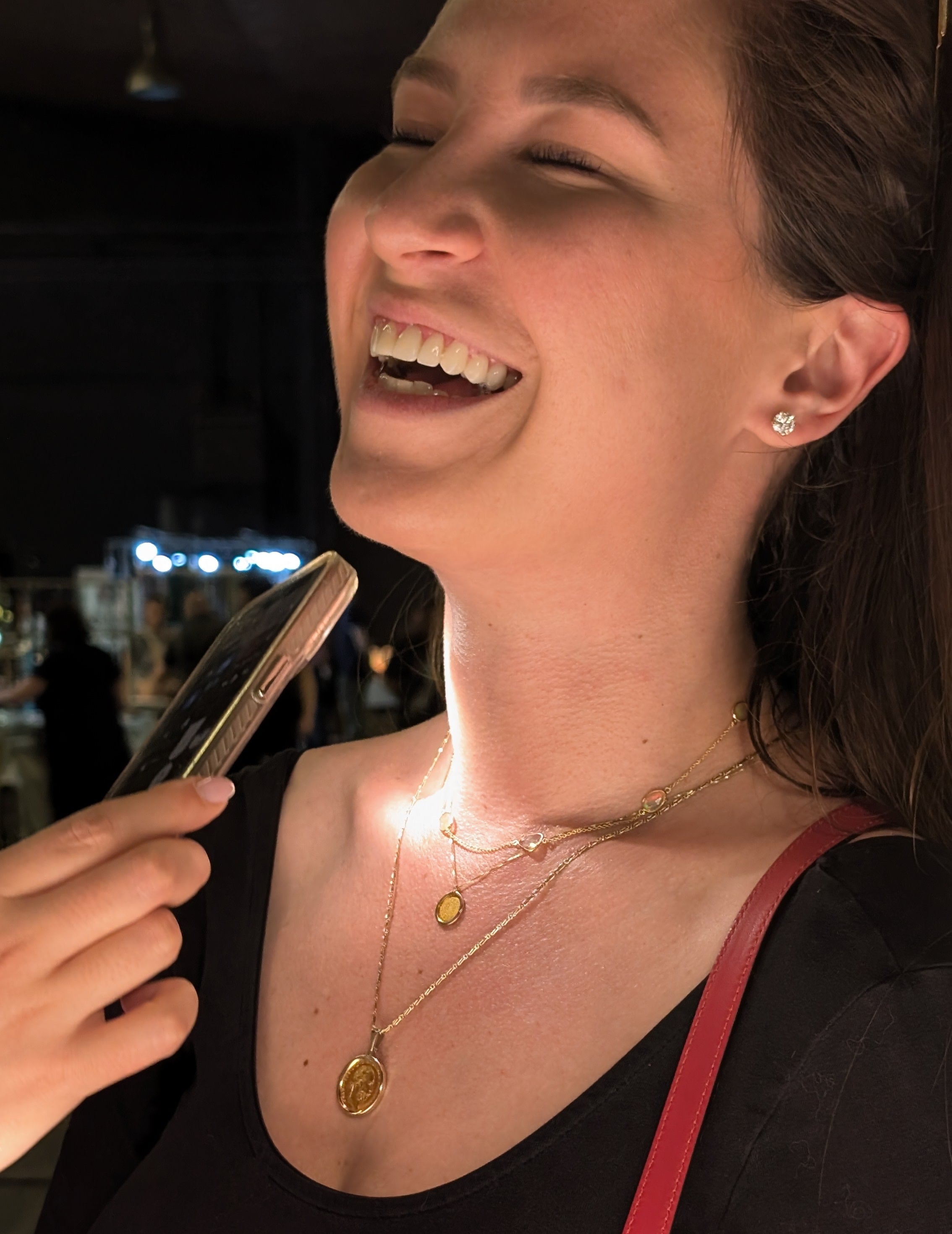 Woman wearing gold necklaces with a blurred background