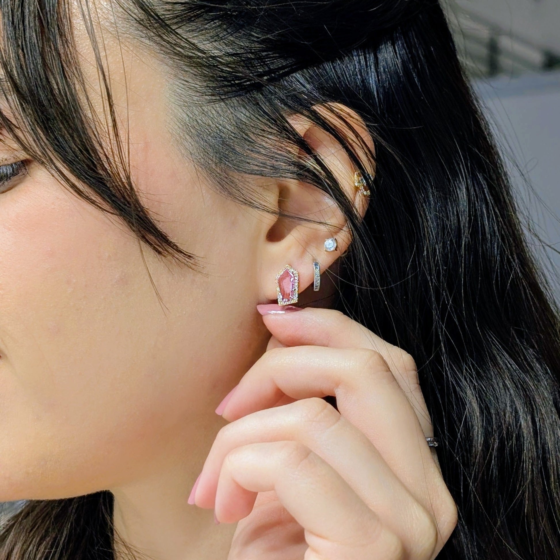 Close-up of a person wearing a pink sapphire studs with diamonds 
